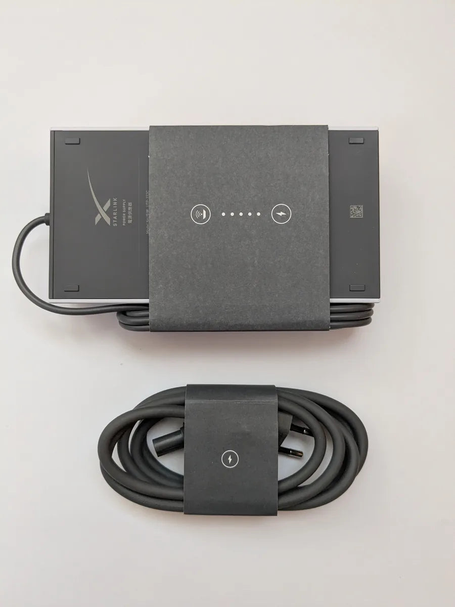Genuine Starlink Gen 3 power supply in its factory sleeve with the coiled AC cable below it.