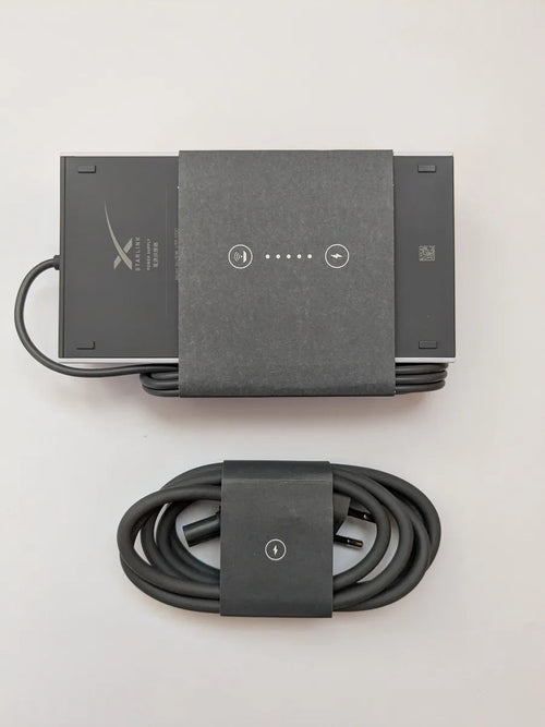 Genuine Starlink Gen 3 power supply in its factory sleeve with the coiled AC cable below it.