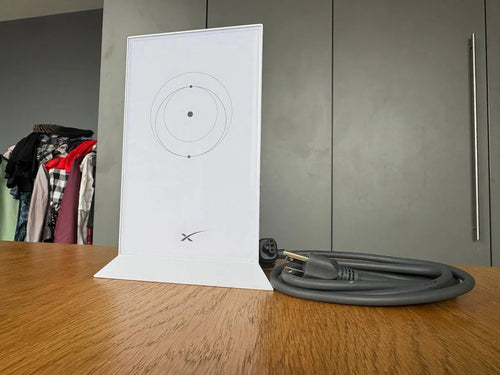 Wide view of the Starlink Gen 2 router upright on a wooden table in a home interior setting.