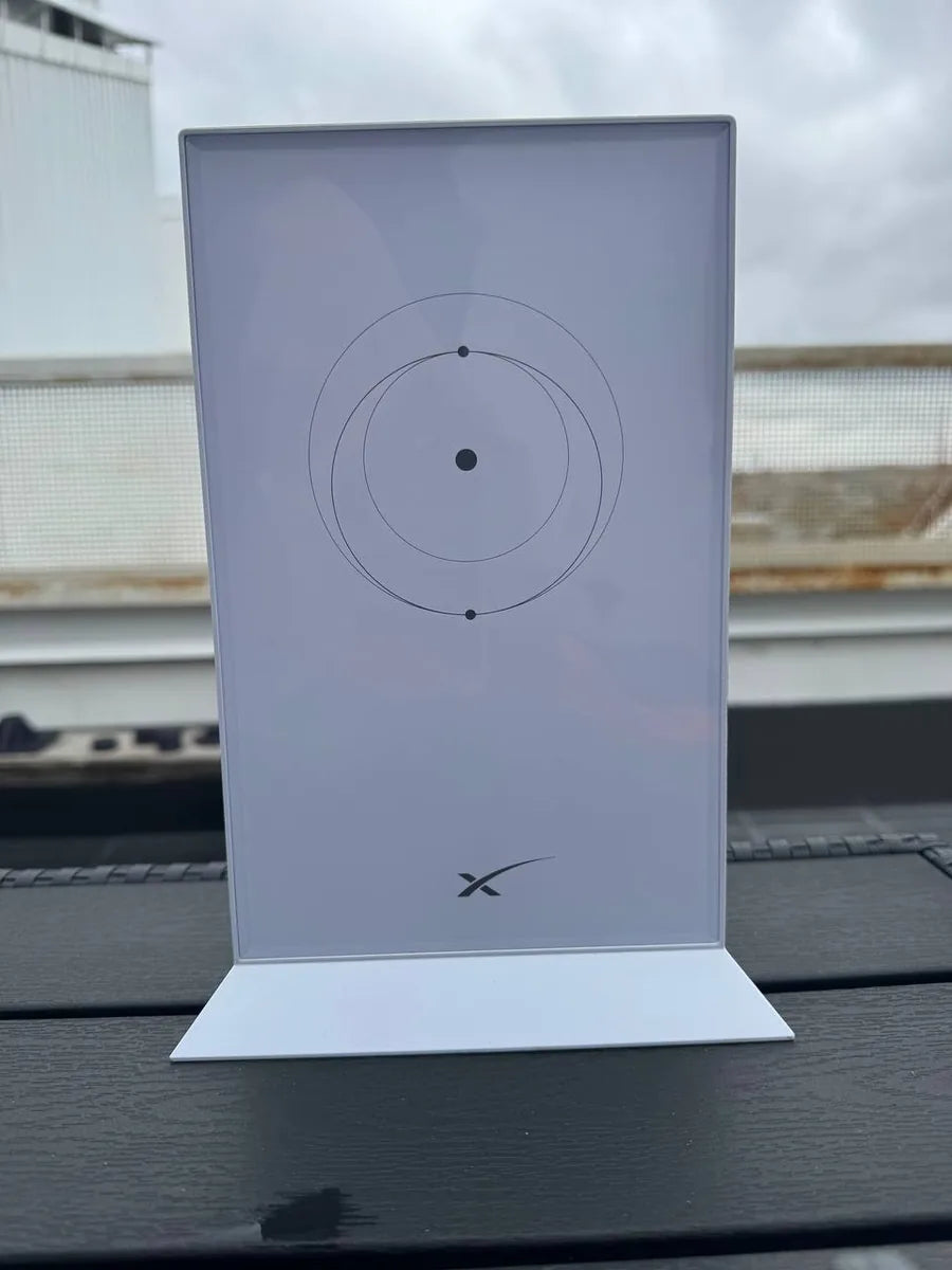 Genuine Starlink Gen 2 router standing on a dark outdoor table, front face and logo visible.
