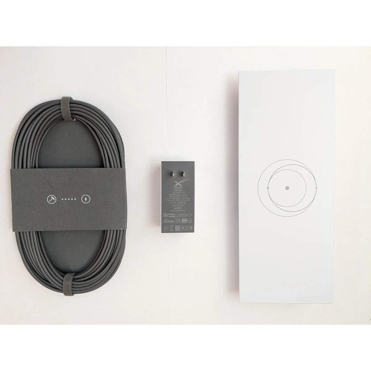 Flat lay of the Starlink Gen 3 router kit: coiled cable, power supply and the router itself.