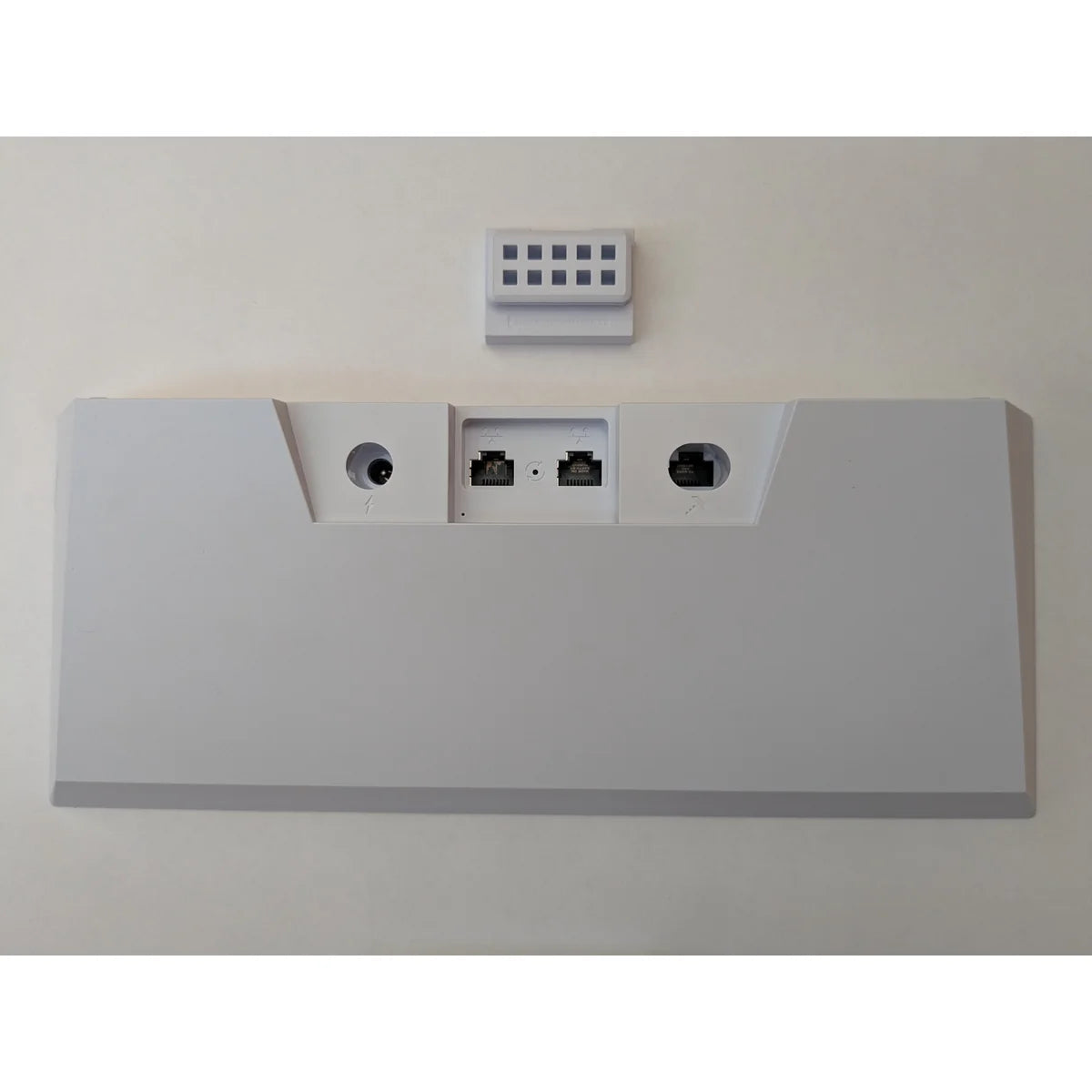 Starlink Gen 3 router laid flat from behind, with the small cable clip supplied alongside it.