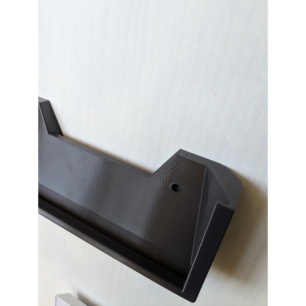Angled view of the empty StarMax bracket on the wall, showing the cradle and printed finish.