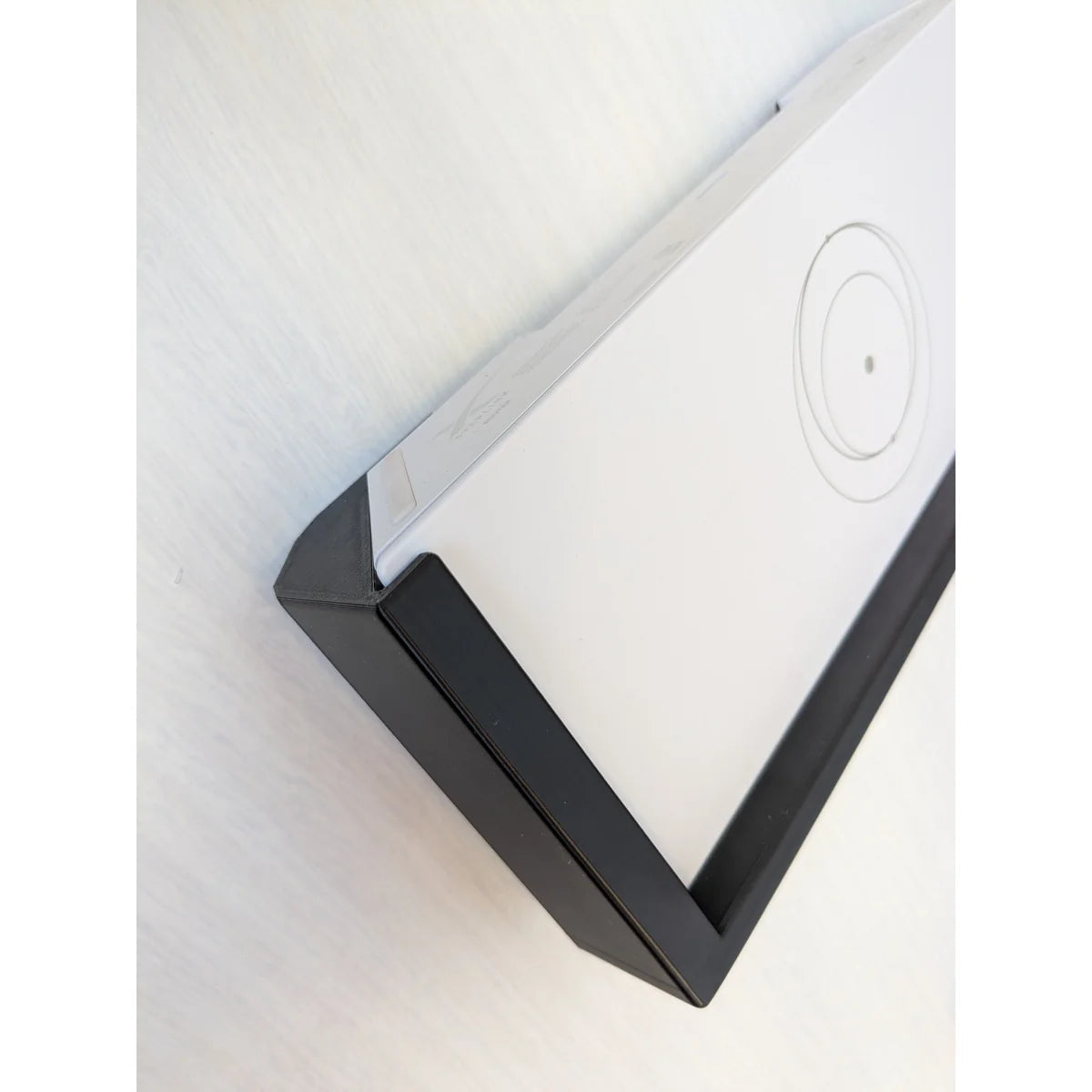 Close-up of the bracket corner gripping the Starlink Gen 3 router, showing the moulded lip.
