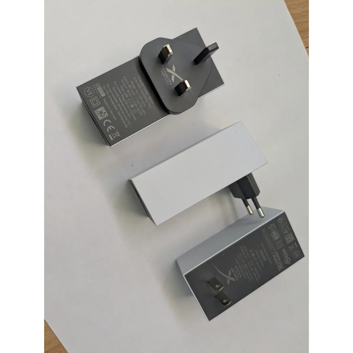 Starlink Mini power supply UK Type G plug beside the EU Type C version, part numbers visible.
