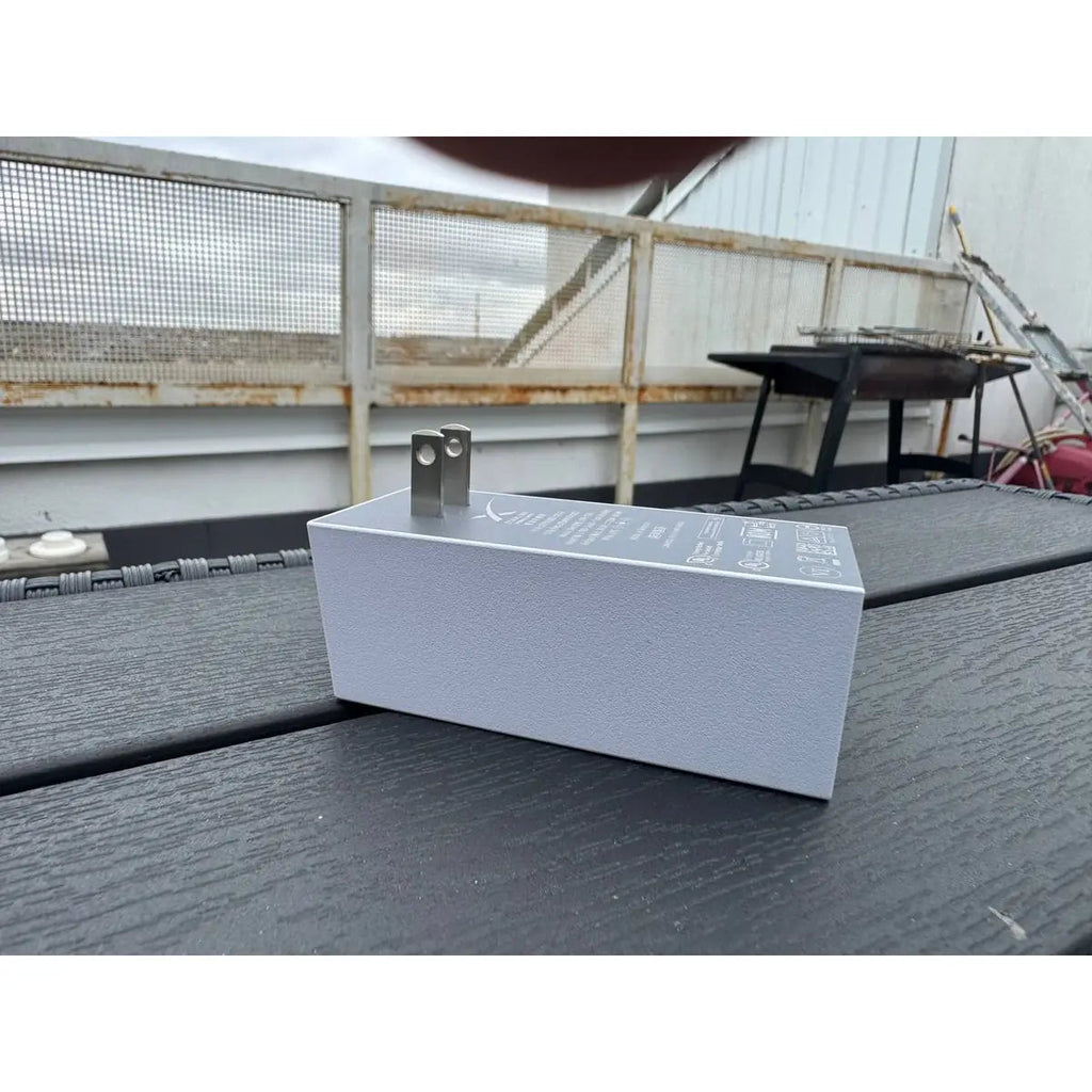 White housing of the genuine Starlink Mini power supply with folding US plug pins, outdoor view.
