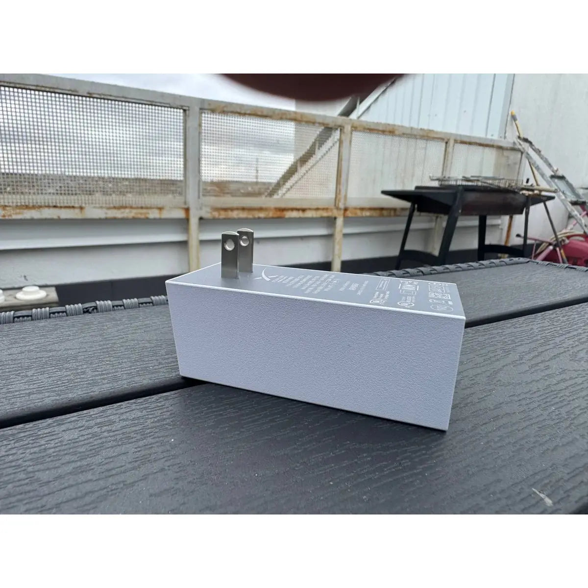 White housing of the genuine Starlink Mini power supply with folding US plug pins, outdoor view.