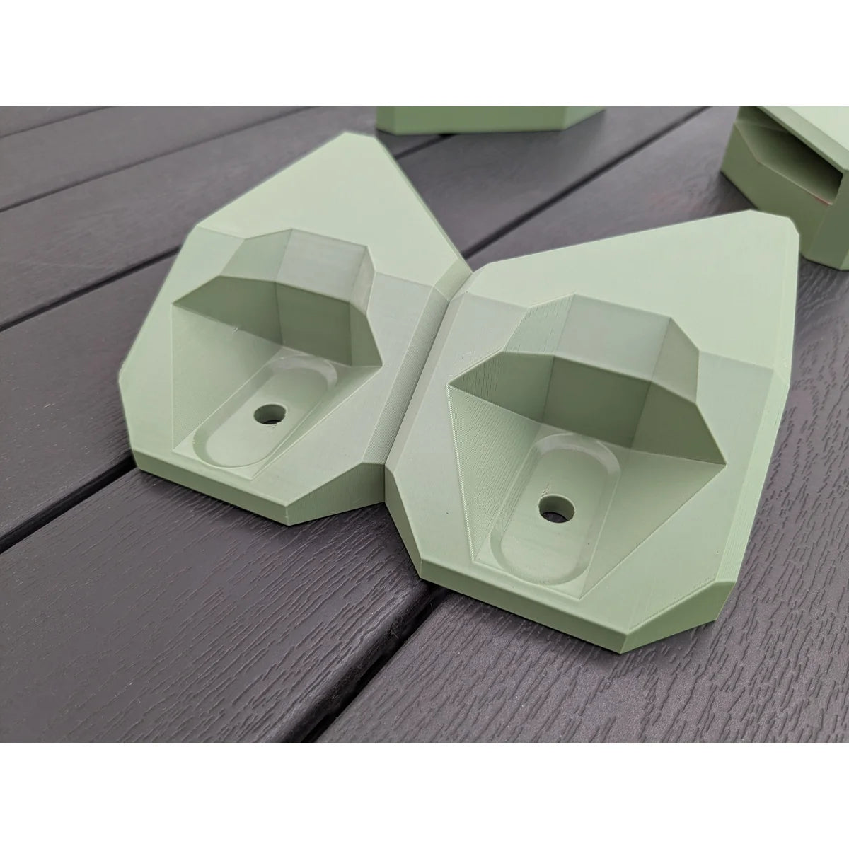 Two StarMax corner brackets side by side, showing the printed wall structure and bolt recess.