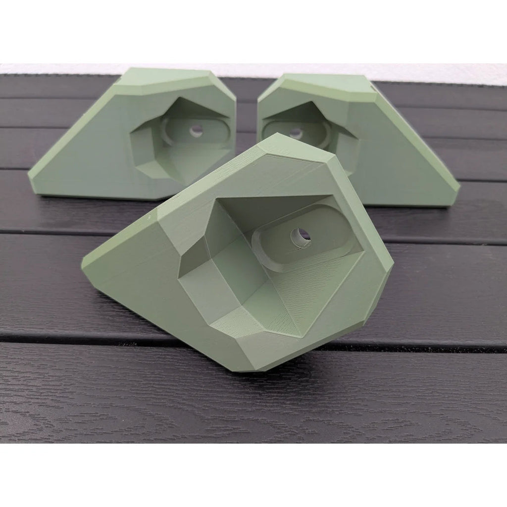 Three StarMax corner brackets viewed from underneath, showing the recess and slotted bolt hole.