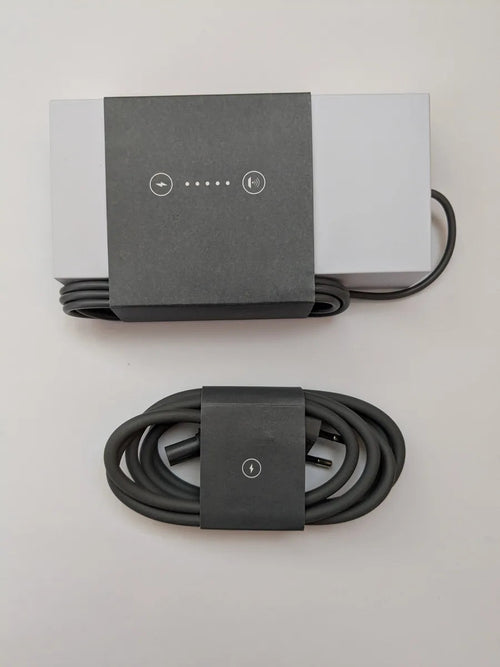 Overhead view of the Starlink power supply and its separately coiled AC cable on a pale surface.