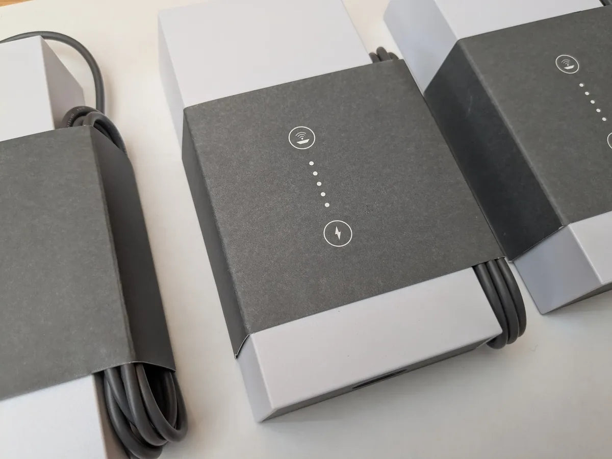 Row of packaged Starlink power supplies with their cables wound around the factory sleeves.