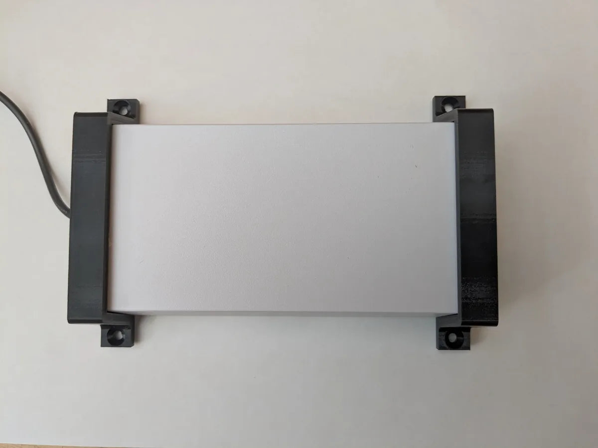 Starlink power supply seen from above with StarMax wall mount brackets fitted at both ends.