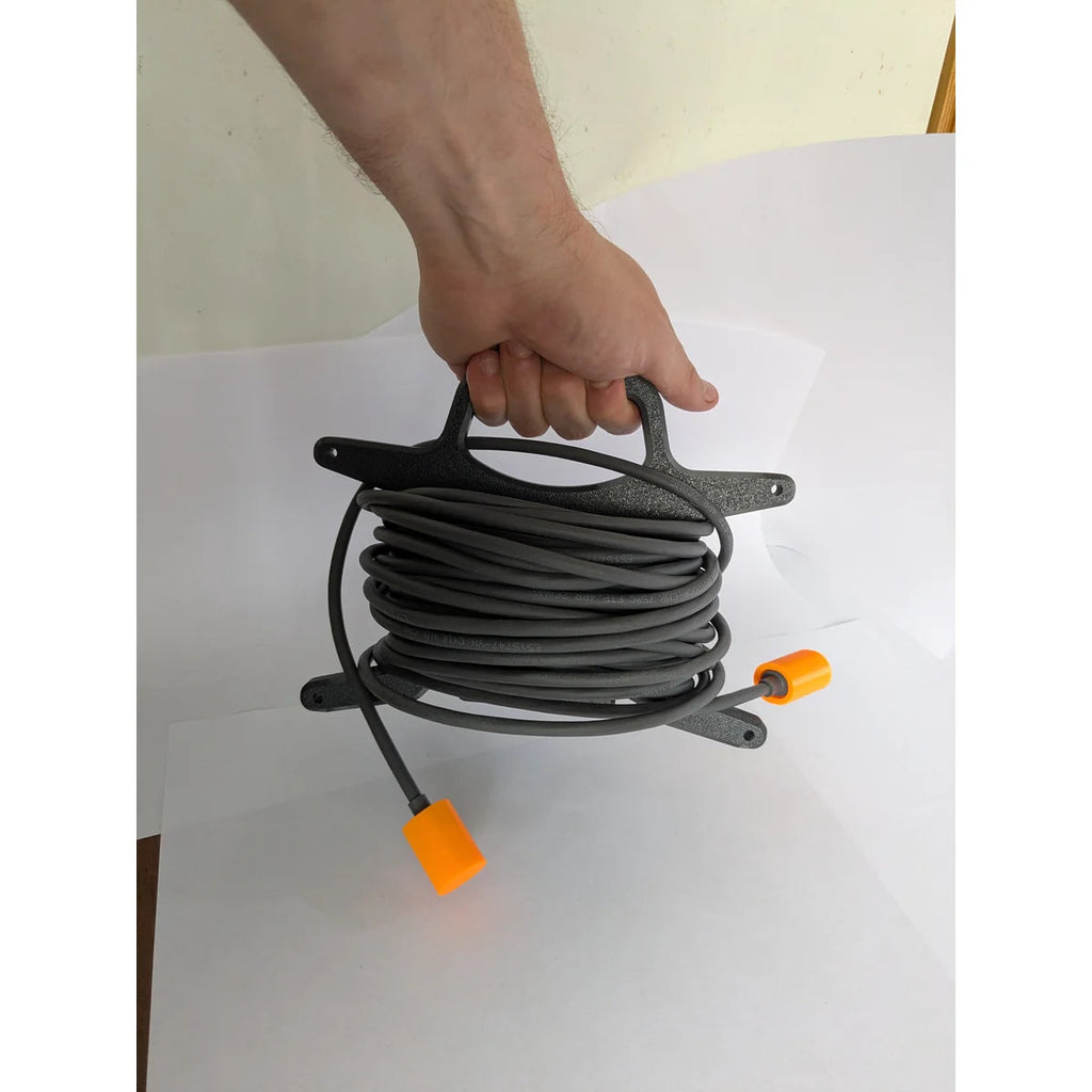StarMax cable caddy carried by its handle with the full 15 m Starlink RJ45 cable wound on it.
