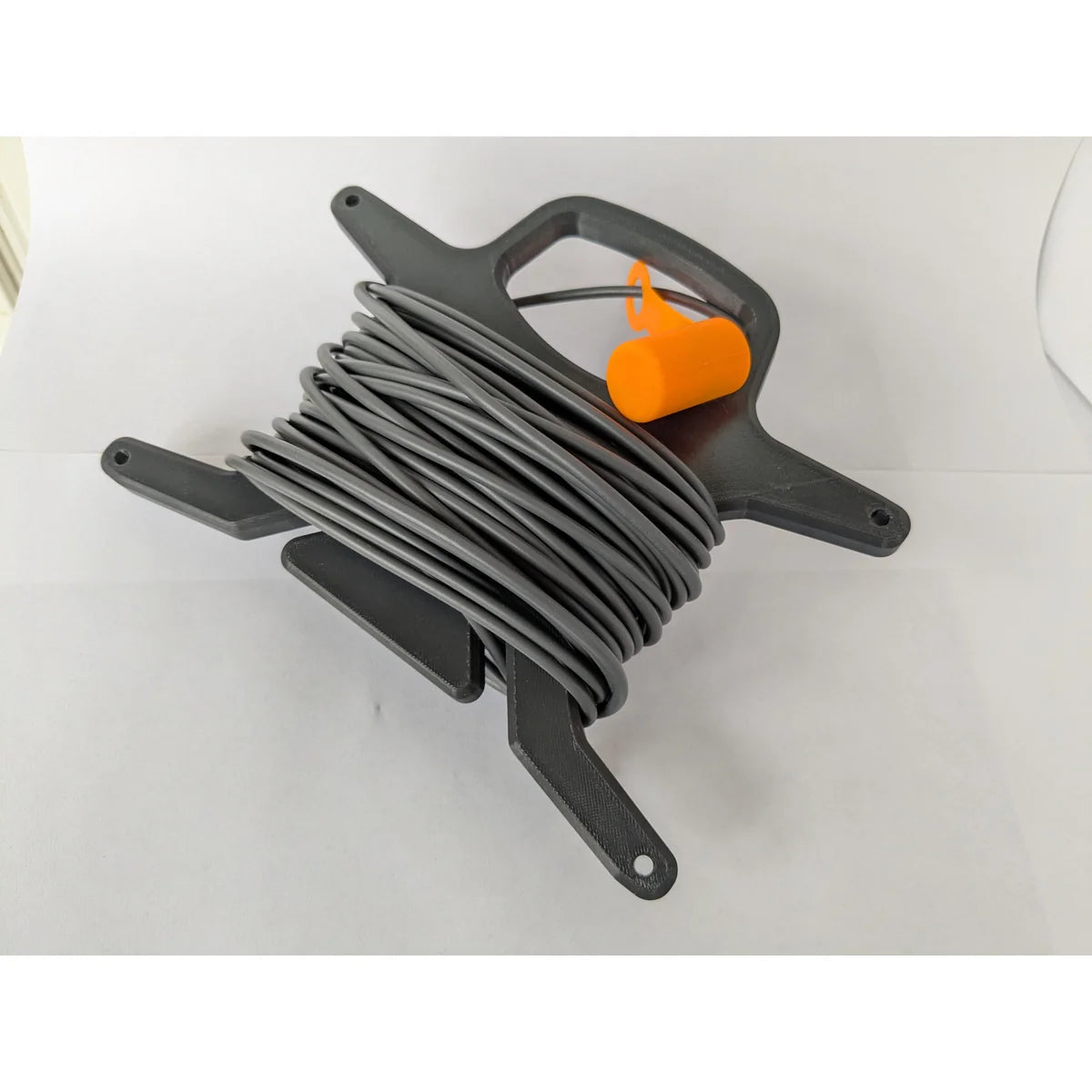 Top view of the StarMax 3D-printed cable caddy with a cable wound around its central spool.