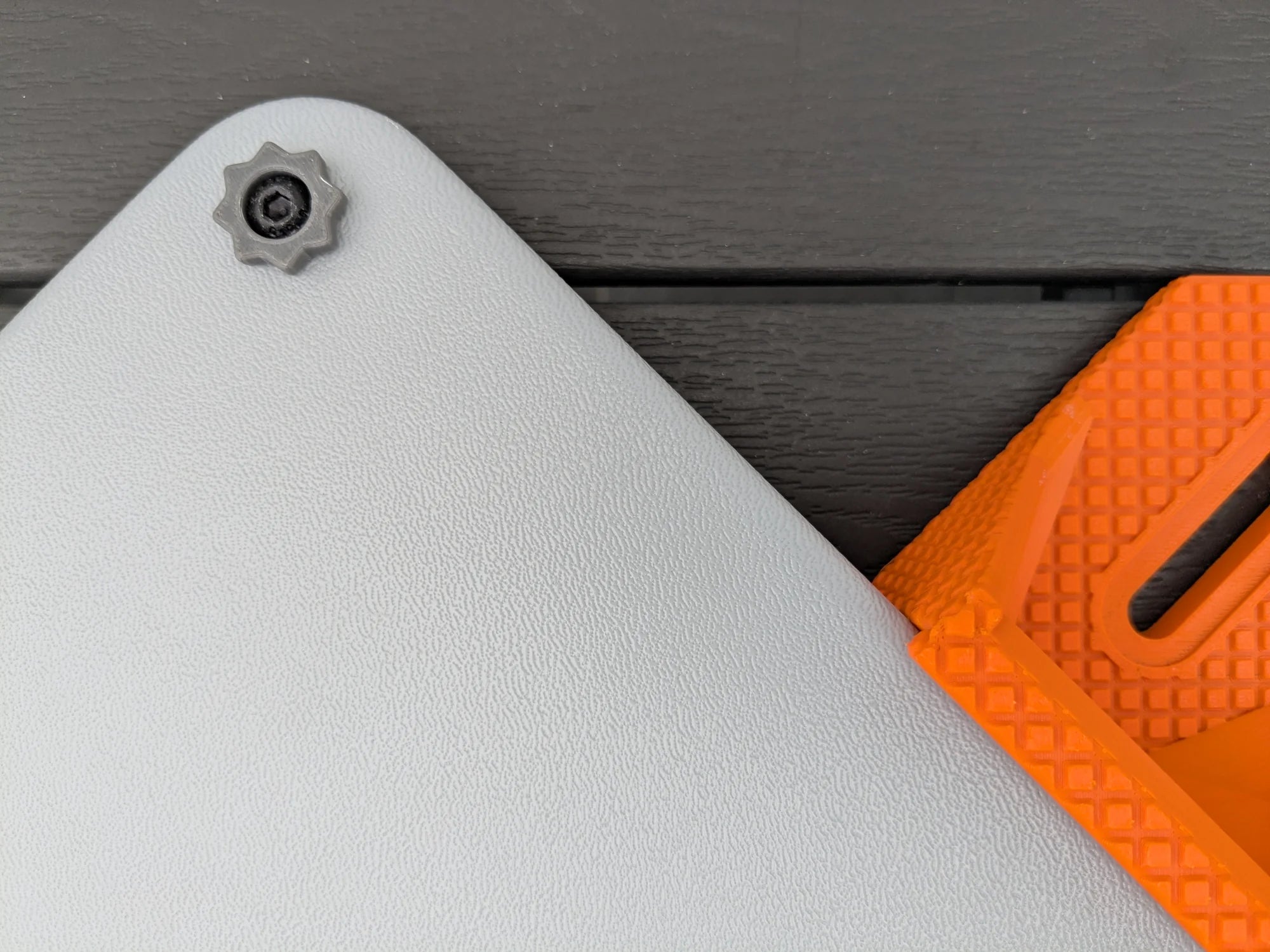 Macro view of an orange StarMax bracket showing the moulded slot and fine surface texture beside the case.