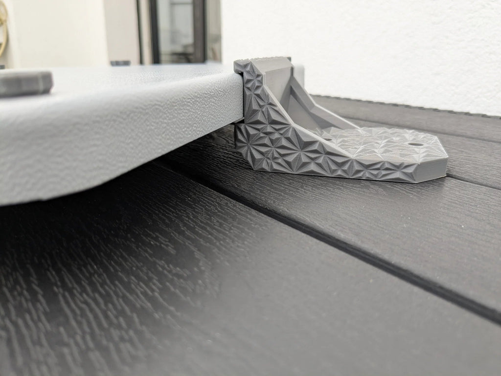 Low-angle side view of a StarMax bracket supporting the edge of the Starlink Mini armor case.