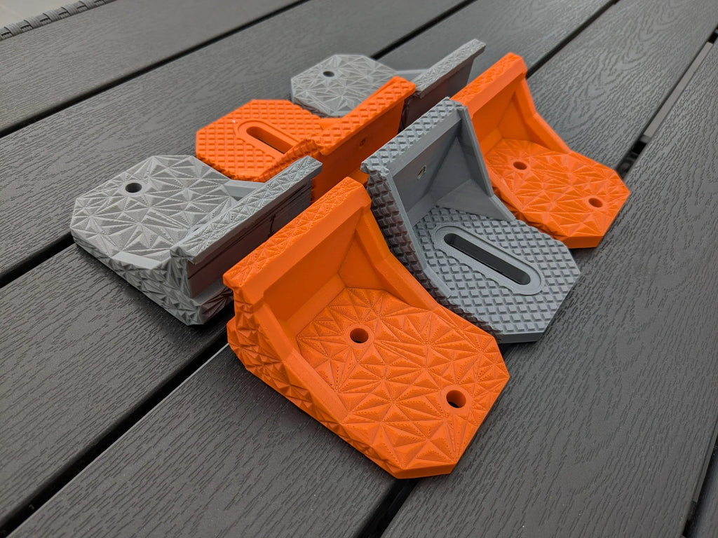 Grey and orange StarMax brackets grouped together showing both the twin-hole and slotted fixing options.