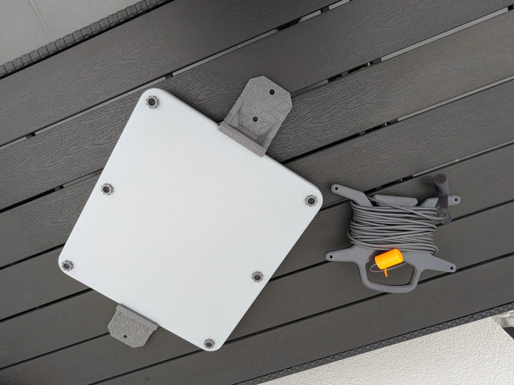 StarMax armor case with mounting brackets alongside the 3D-printed cable caddy holding a coiled Starlink cable.