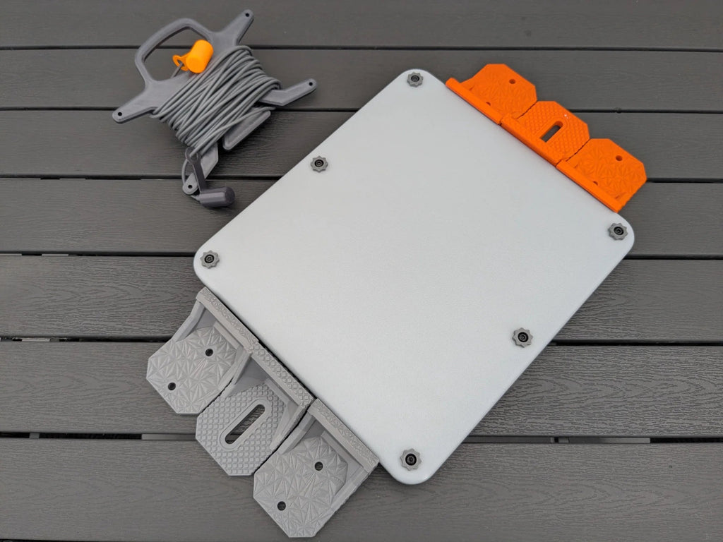 Starlink Mini armor case with orange brackets on one edge and grey brackets on the other for comparison.