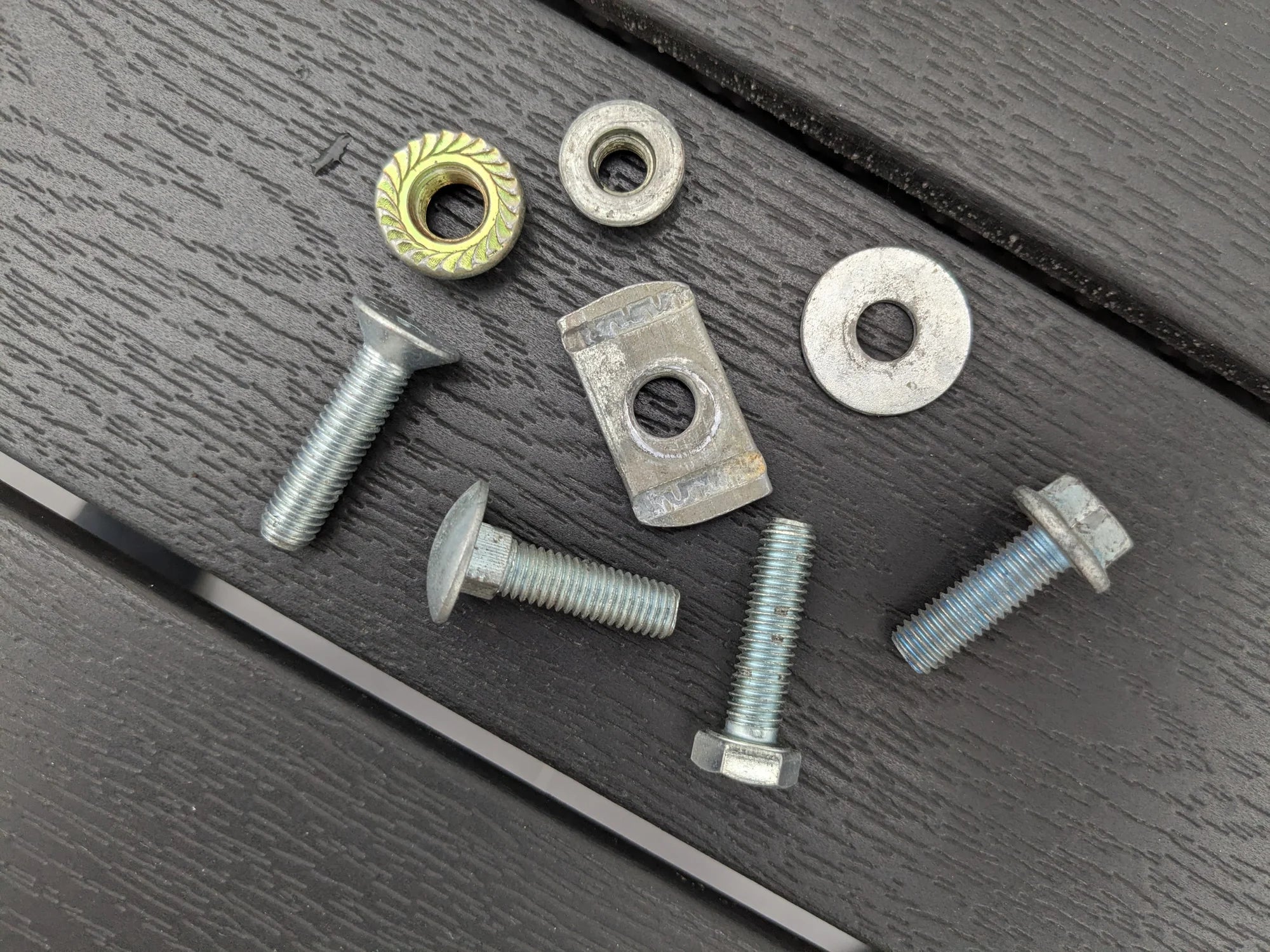 Zinc-plated bolts, flange nuts, washers and a T-slot nut used to fix the StarMax brackets to a roof rack.
