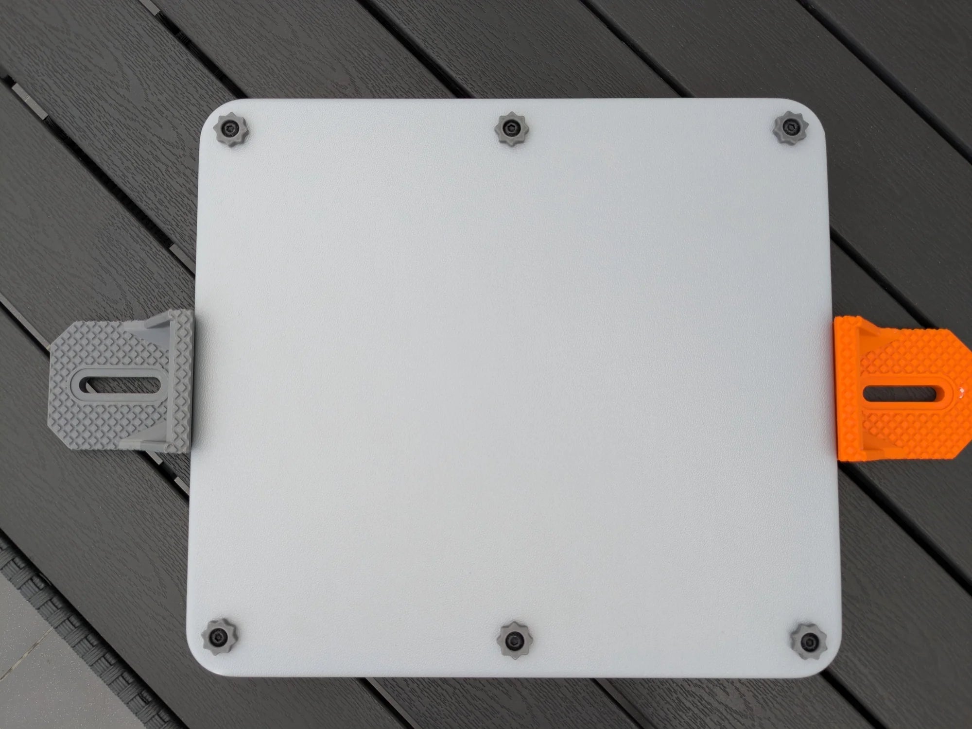 Starlink Mini armor case flanked by grey and orange StarMax brackets with elongated adjustment slots.