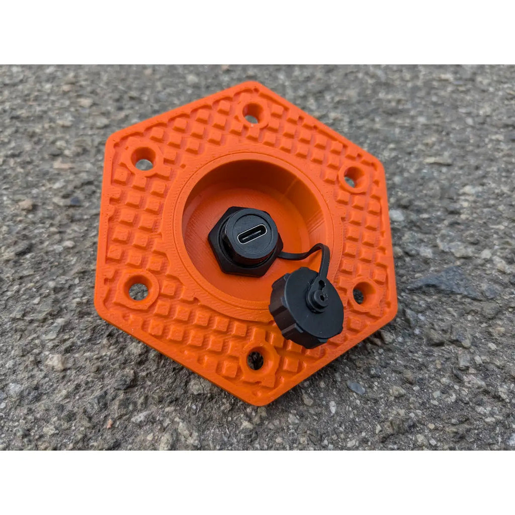 StarMax USB-C panel socket in orange with the threaded weather cap unscrewed and hanging aside.